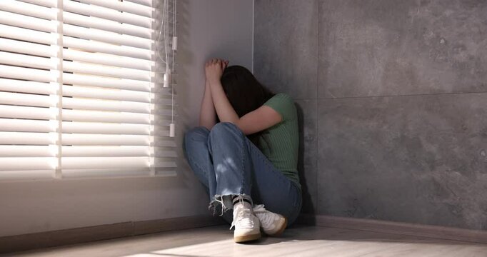 Woman suffering from paranoia near window indoors