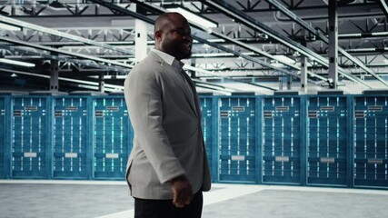 Happy businessman walking in data center, assessing rackmounts capacity before investing. Jolly management executive overseeing server farm built for business storage gear, camera A - Powered by Adobe