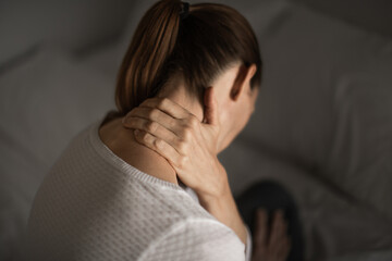 Female massaging her sore stiff neck 