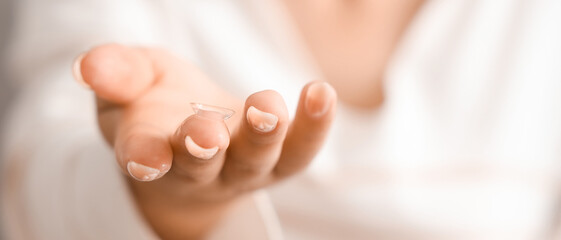 Young woman with contact lens at home, closeup