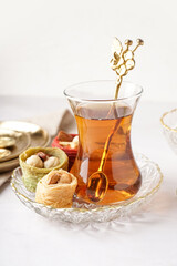 Glass of tea and Turkish delight on white background