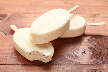 Tasty chocolate covered ice cream on wooden background
