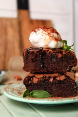 Plate with pieces of tasty chocolate brownie and ice cream on table