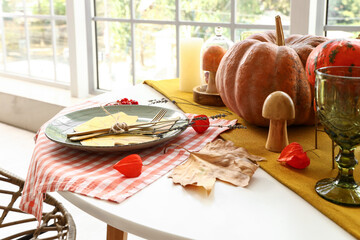 Autumn table setting with pumpkins, grapes and leaves
