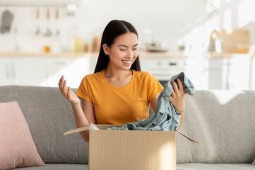 Satisfied buyer with online purchase. Happy korean woman opening and unboxing parcel cardboard box,...