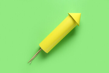 Yellow firework rocket on green background