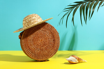 Stylish female bag, straw hat, seashell and palm leaf on color background