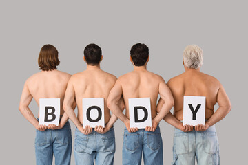 Group of men with word BODY on grey background, back view. Body positive concept