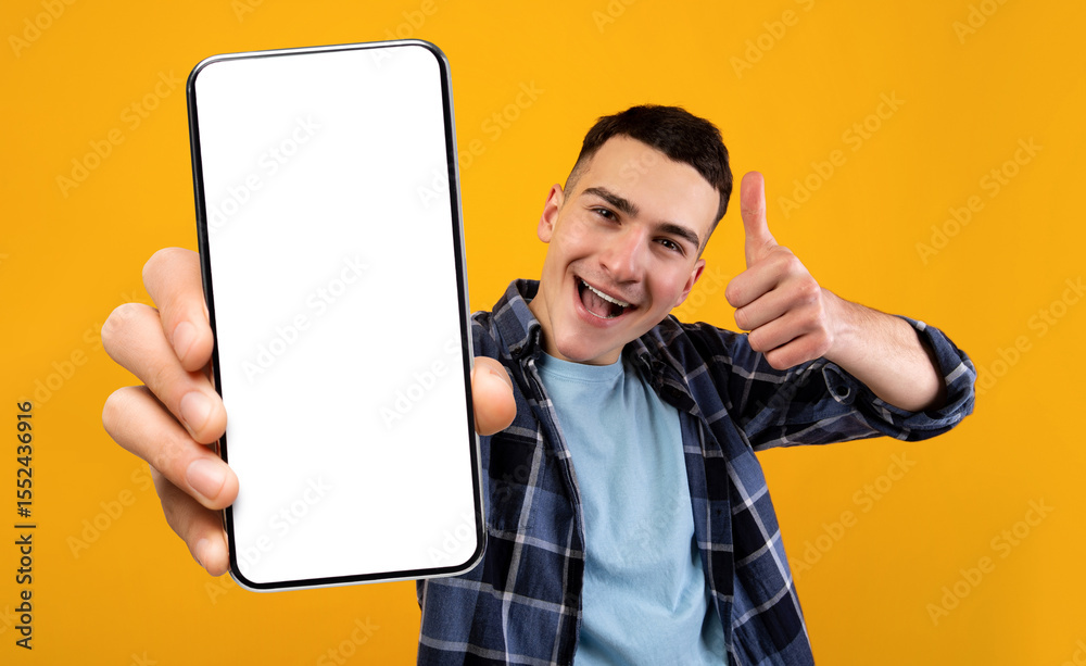 Poster mobile application ad. excited young guy showing smartphone with blank white screen and gesturing th