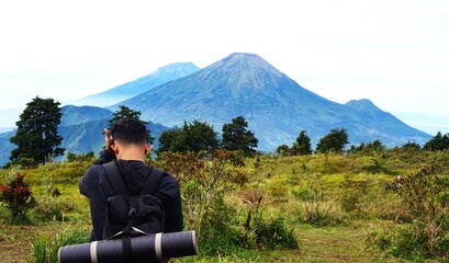 a man in a black jacket enjoying the beautiful mountain view