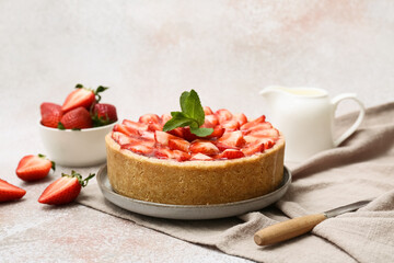 Plate of sweet strawberry tart with mint and jug of fresh milk on white background