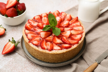 Plate of sweet strawberry tart with mint and jug of fresh milk on white background, closeup