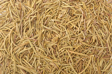 close-up macro view of dried rosemary in full frame, thin needle like dried aromatic herbal leaves taken straight from above, culinary botanical or natural wellness theme