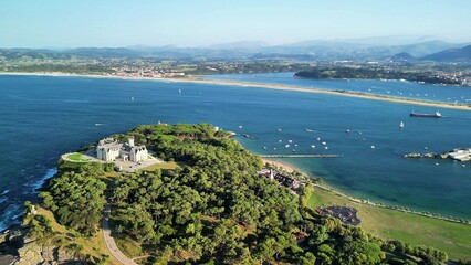 Obraz premium An aerial shot beautifully captures a breathtaking coastline adorned with lush greenery and numerous sailing boats