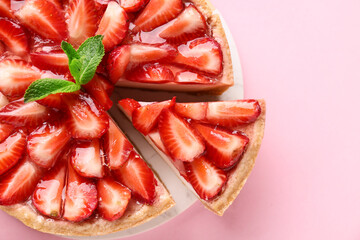 Board of cut sweet strawberry tart with mint on pink background