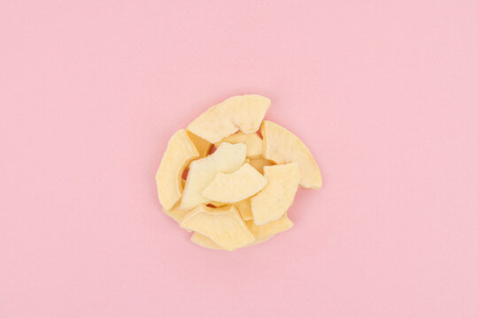 Dried Apple Slices on Pastel Pink Background &ndash; Healthy Snack Concept