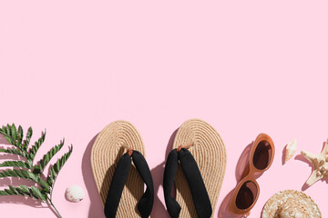Composition with stylish wicker flip-flops, sunglasses and green leaf on pink background, closeup