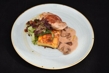 Chicken breast with spicy sauce, salad and mushrooms often served as a main course at a restaurant