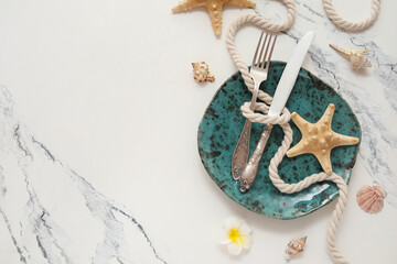 Beautiful table setting with plate, cutlery, rope and starfishes on marble background