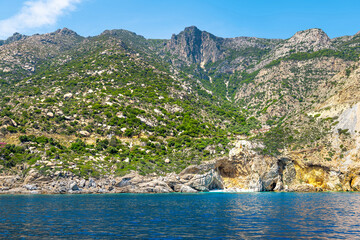 Famous Seychelles beach dramatic landscape and people tourists on Ikaria island, Greece longevity blue zone by Icarian sea ocean water
