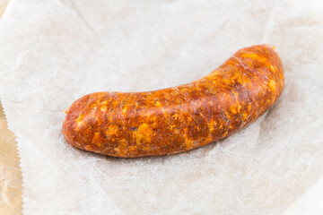 Pork chorizo sausage Spanish food closeup red uncooked raw meat hot spicy product on wrapping paper package