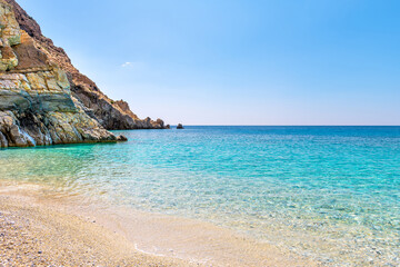 Seychelles beach in Magganitis, Ikaria island Greece by Icarian sea of crystal clear green turquoise water, rocky cliffs coast water level view