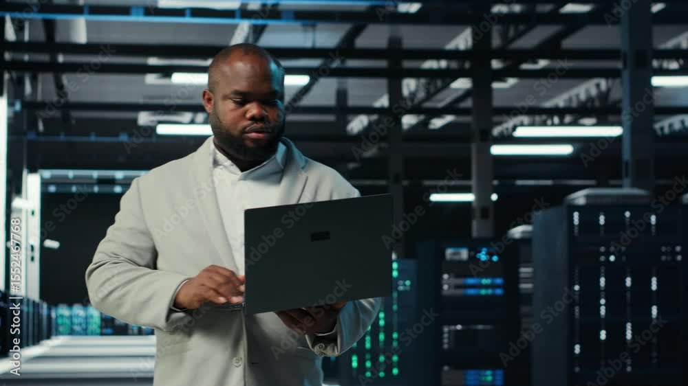 Poster programmer in data center using laptop, testing equipment failover scenarios. server farm it profess