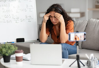 Fatigue From Work. Tired young woman in headset feeling headache or stress, touching and massaging...
