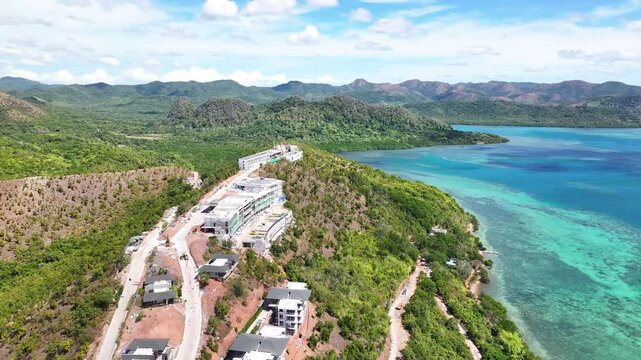 Coastal Hillside Resort Under Development In Busuanga, Palawan, Philippines, Surrounded By Lush Greenery And Turquoise Waters. aerial pullback shot