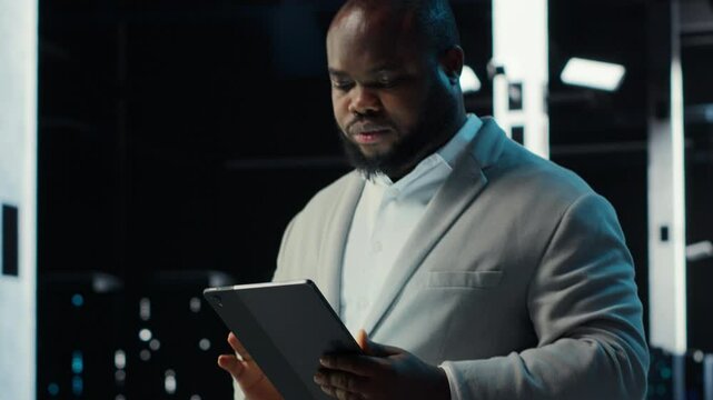 Admin in data center using tablet to develop disaster recovery plans. IT expert walking in server farm, testing failover scenarios, protecting data during disruptions, camera B