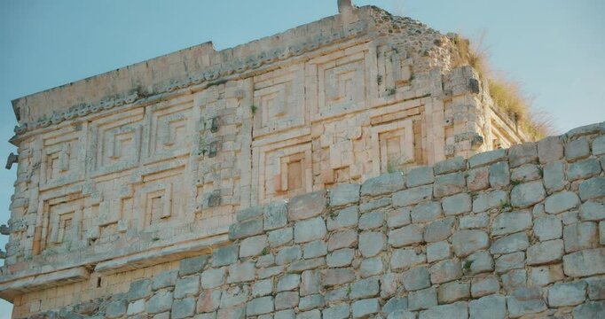 Facade of ancient Mayan ruins with decorative geometric patterns in Yucatan Mexico