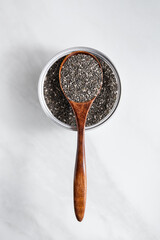 Close-up of chia seeds in a glass jar with a wooden spoon. Healthy superfood concept, ideal for...