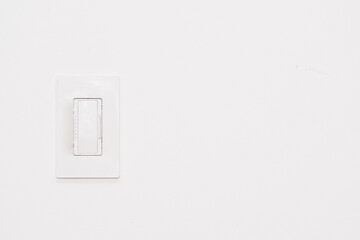White dimmer light switch on white wall with copy space