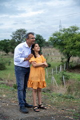Cheerful Indian father spending fun time with his little daughter or showing something to his...