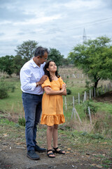 Cheerful Indian father spending fun time with his little daughter or showing something to his...