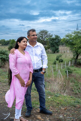Indian woman pointing with finger showing something to her husband. Indian couple looking somewhere...