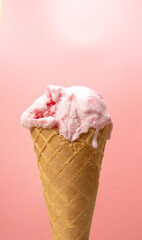 Vertical Front view delicious waffle cone strawberry ice cream on pink background.