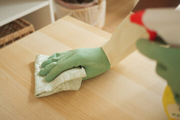 Cleaning a wooden surface with gloves and cloth