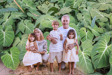 Grandfather, grandmother, and grandchildren enjoying a moment of joy and relaxation as they pose...