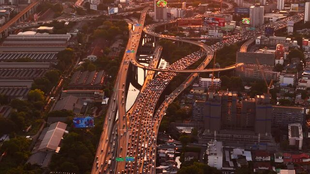 Sunset traffic flows along urban multi level freeway during peak rush hour