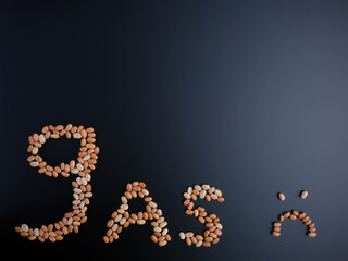 Letter word text Gas made out of pinto beans and a sad frown face on a dark gray background. Room...