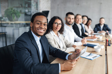 African American Businessman On Business Conference, Smiling To Camera During Corporate Meeting...