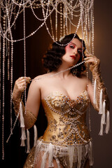 Caucasian female artist in golden Victorian-inspired corset costume, front view, dark background. Ideal for retro, Edwardian, cabaret, or theatrical performance themes.