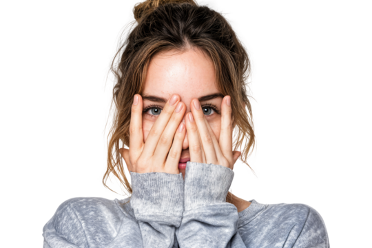 Young woman covering part of face with hands looking forward with shy and curious expression isolated on transparent background