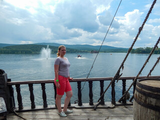 A girl stands in a ship and is wearing a purple shorts