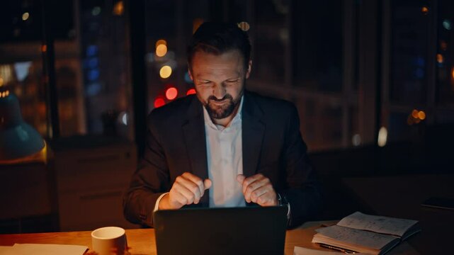 Frustrated executive reacting failure at desk night. Mad employee hitting table