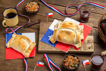 Chilean national holidays Celebration with Traditional Empanadas and Fresh Sauce on Wood Table, september 18th concept and chilean decoration