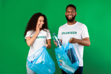 Couple Of Multicultural Volunteers Picking Plastic Litter And Bottles In Bags Cleaning Environment...