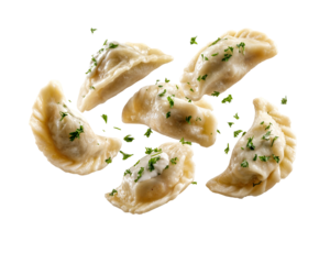 Traditional Polish pierogi dumplings with sour cream and parsley garnish floating isolated on transparent background