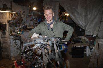 Portrait of young adult Caucasian man standing in workshop assembling and repairing custom...